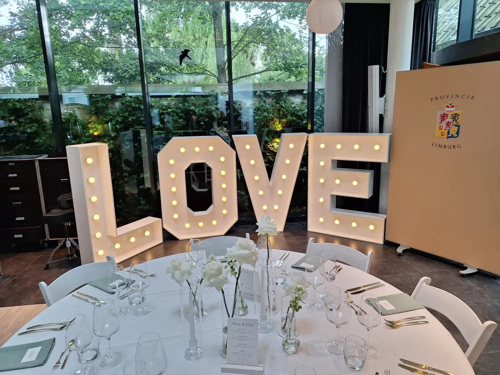 Verlichte LOVE letters in warm wit op een trouwlocatie