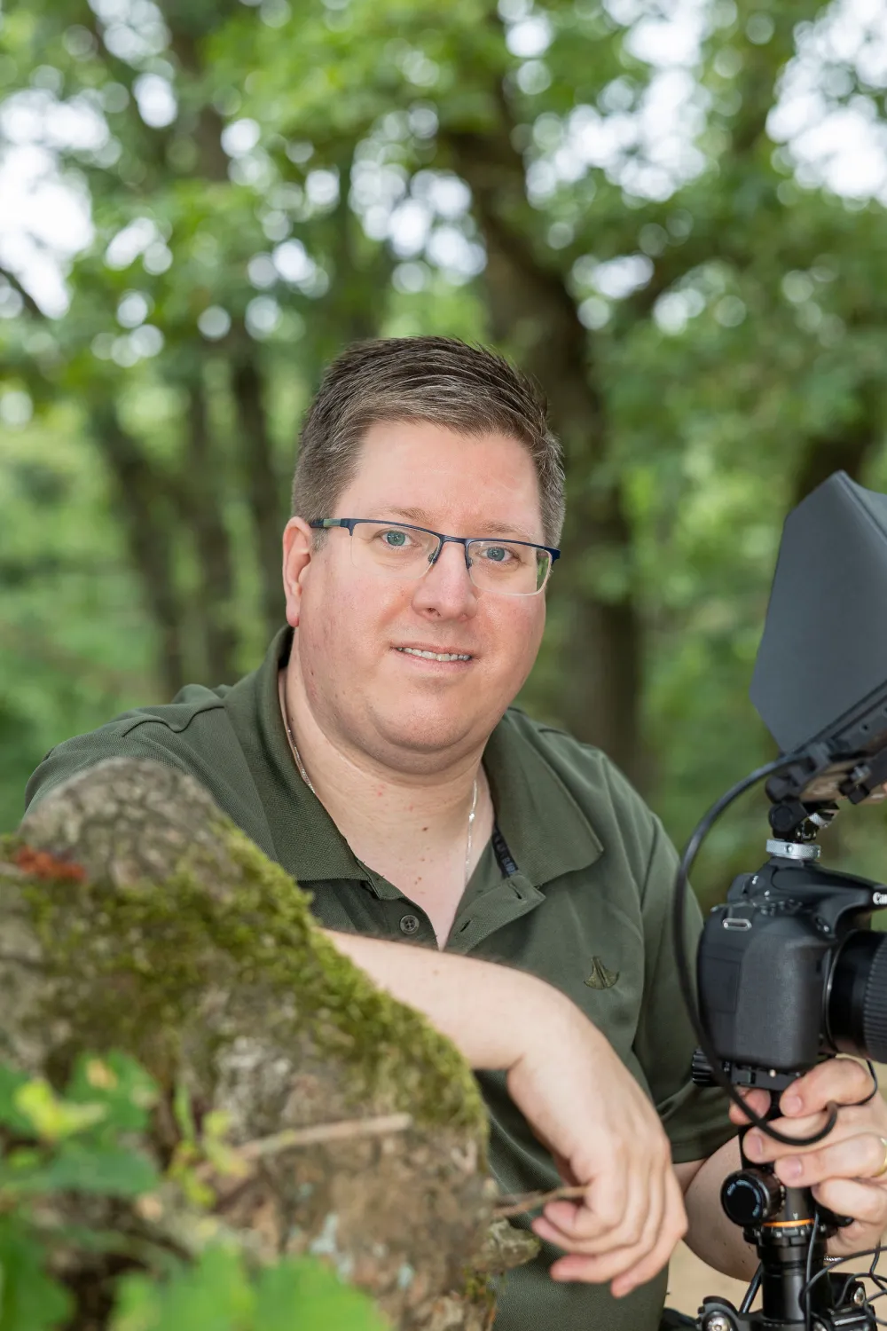 Man met camera op statief in het bos